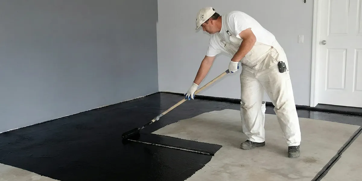 basement waterproofing professional applying waterproof coating to protect a basement floor in Staten Island, NY
