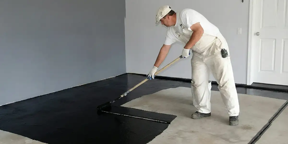 basement waterproofing professional applying waterproof coating to protect a basement floor in Staten Island, NY